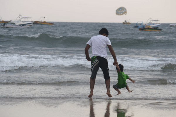 father and son playing at beach